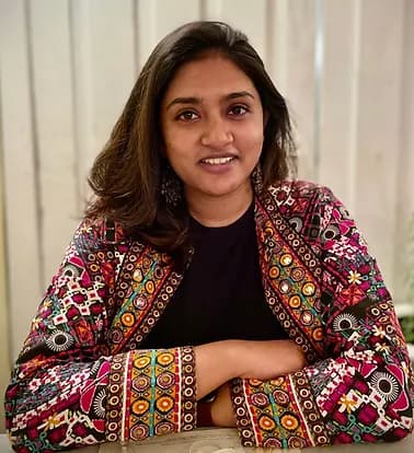 Sruti sitting on chair in office.
